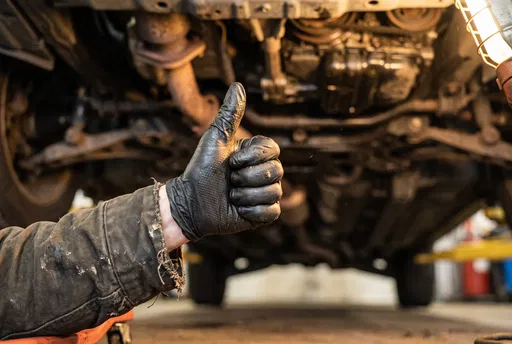 Mechanic Hand Giving Thumbs Up Under Car
