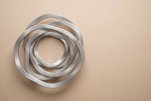 Brushed Aluminum Rings on Beige Background