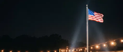 Illuminated American Flag Flying at Night