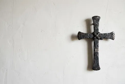 Wrought Iron Cross on White Plaster Wall