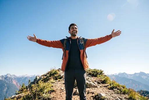 Smiling Hiker With Arms Outstretched on Mountain