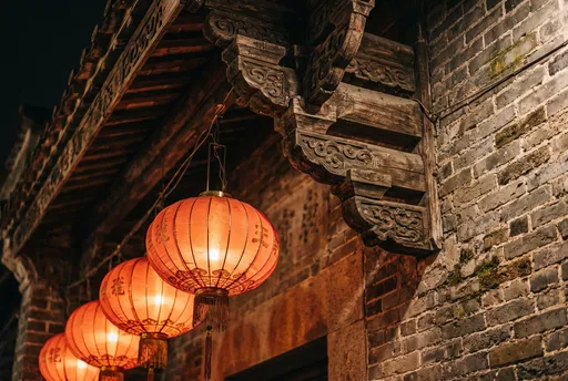 Glowing Red Lanterns Under Ancient Wooden Eaves