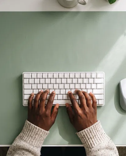 Hands Typing on Minimalist White Keyboard