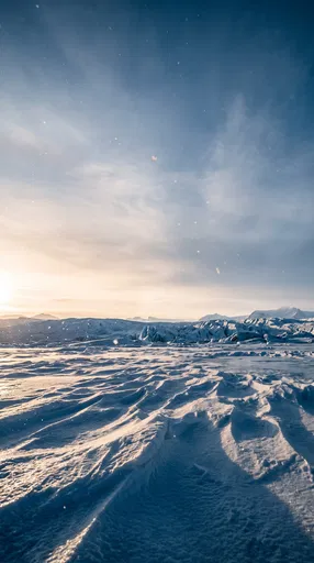 Sunlit Glacial Snow Ridges Under Winter Sky
