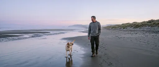 Man Walking Yellow Labrador on Dawn Beach