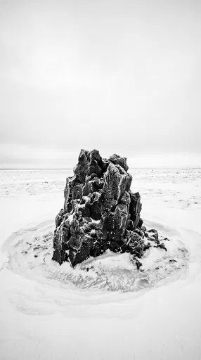 Solitary Frosted Basalt Rock in Snow