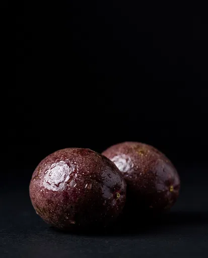 Two Wet Passion Fruits on Black