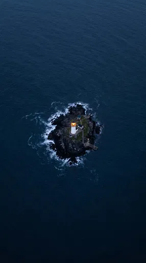 Aerial View of Isolated Lighthouse in Dark Ocean