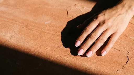 Hand With Pink French Manicure On Terracotta