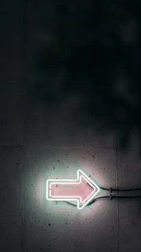 Pastel Neon Arrow on Concrete Wall