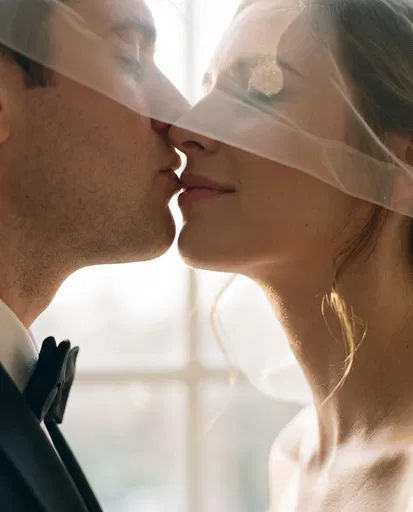 Couple Kissing Beneath Shared Bridal Veil