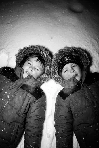 Two Children Lying in Snow
