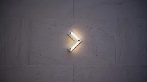 Backlit Frosted Glass Arrow on Limestone Wall