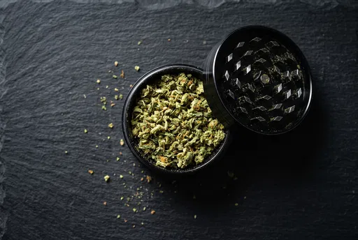 Black Metal Grinder With Ground Cannabis